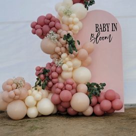 A decorative balloon arrangement with the phrase "BABY IN BLOOM" for an event.