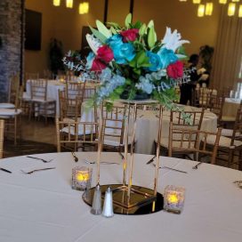 Elegant table setting with floral centerpiece in a banquet hall.